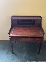 Front view of writing desk showing leather top, hutch and drawer