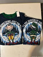 Two navy elf graphic shirts front and back visible
