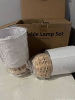 Two table lamps wrapped in plastic in front of box labeled Table Lamp Set