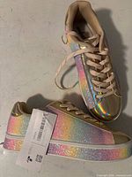 side and top view of both sneakers showing rainbow glitter finish and tag