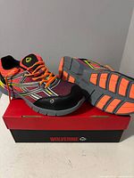 Both sneakers displayed on box showing uppers and sole tread