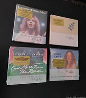 Front view of four sealed 2-CD sets
