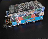 stack of three VHS tapes and one book
