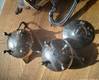 Undersides of creamer and sugar bowl plus lid and part of pot showing feet and tarnish