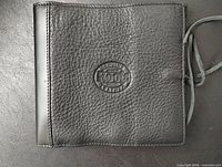 Front of black Roots leather holder showing embossed logo