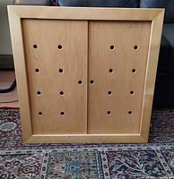 Front view of cabinet with doors closed showing perforated panels