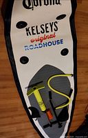 Top view of branded paddle board with pump, hose, fin, paddle components and repair kit displayed