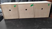 Front view of three identical unfinished birch plywood Moppe boxes with circular pull holes