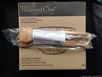Box showing Pampered Chef branding, bowl illustration, and bagged bamboo utensils