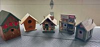 Front view of five decorative birdhouses displayed side by side