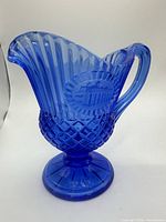 Full view of cobalt blue pressed glass pedestal pitcher, handle and Mount Vernon medallion visible