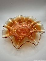 Top view of marigold carnival glass bowl showing ruffled edge and floral motif