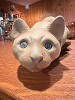 Front view of ceramic cat focusing on face and blue eyes