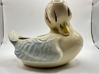 Side view of ceramic duck vase showing color and shape