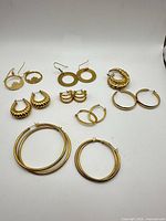 Overview of all eight pairs of gold-tone hoop earrings