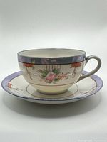 Side view of tea cup on saucer showing floral motif and rim detail
