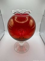 Full view of red glass pedestal vase front