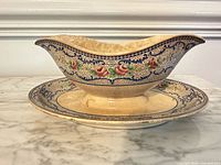 Side profile showing attached gravy boat and underplate with floral pattern