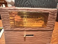 Brass label on decanter base showing product details