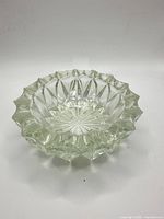 Top view of clear pressed glass dish showing scalloped rim and starburst base