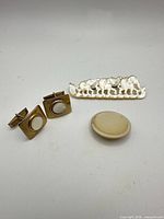 Entire lot showing cufflinks, elephant brooch, round brooch