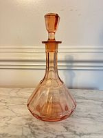 Full view of pink glass decanter with stopper