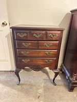 Front view of wooden dresser showing drawer layout and hardware