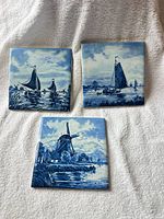 All three blue and white Dutch-style ceramic tiles displayed together