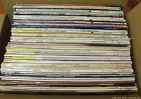 Box filled with vertically stacked 12-inch LP records showing spine titles