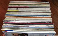 Full stack of 50+ LPs viewed edge-on showing spines