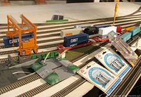 Wide view showing crane, multiple containers, flatcars, ramp pieces and packaged accessories