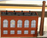 Front view of boiler house and smokestack showing brick walls and windows