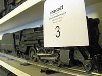 Side view of Lionel 675 locomotive on track, Maxsold lot card visible
