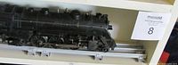 Side profile of black Lionel 1666 locomotive on O-gauge track