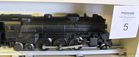 Left side profile of black steam locomotive on track