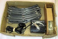 Lot overview showing all components in box: transformer, curved track, power cord, inner divider, cardboard box