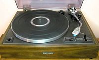 Turntable without record showing platter, tonearm and controls