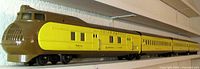 Full side view of four-car streamlined train set on shelf