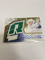 Front of SPx Jake Virtanen rookie card showing green R patch and autograph