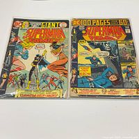 Both bagged Superman Family giant comics side by side