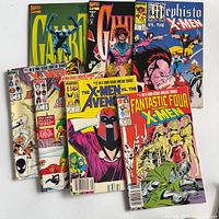 All seven comics fanned out, front covers visible