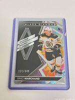 Full view of Brad Marchand Black Diamond card in top loader showing player image, branding, serial number