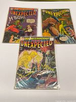 All three comic books laid out in bags