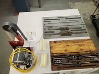 Overall lot showing belt sander, tap & die set plates, wooden case, plastic holders