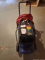 Full view of Campbell Hausfeld air compressor with hose