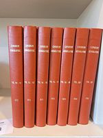 Seven bound volumes showing spines with titles and years