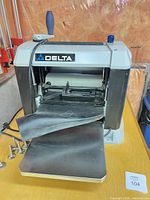Front view of Delta planer showing infeed table, depth crank, dust hood
