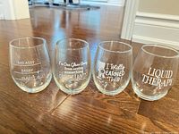 Front view of four stemless glasses showing printed texts