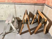 Aluminum two-step stool and two wooden A-frame sawhorses