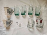 Front view showing all eight pieces: 4 green tumblers, 2 bird ceramic mugs, 2 beer mugs